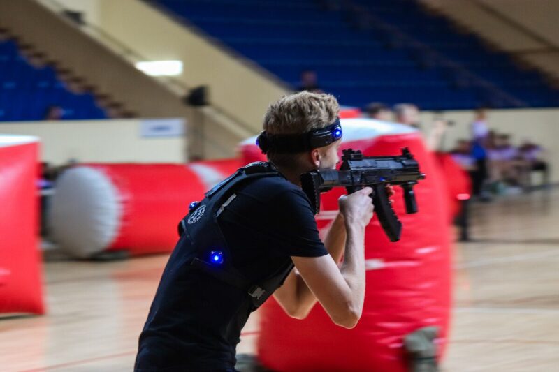 Игрок LASERWAR с оружием в движении за укрытием.